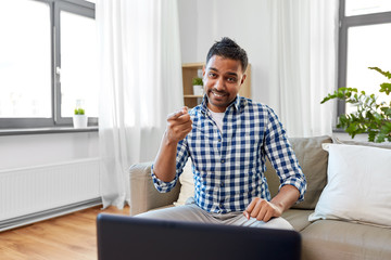 Fototapeta premium blogging, videoblog and people concept - indian male blogger recording video blog at home and pointing to you