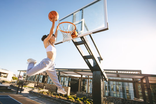 Female playing basketball outdoors