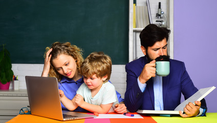 Mom and dad helps child boy. Happy family. Parenting. First time to school. Happy family schooling math together. Children education. Pupil education. Cute pupil and his parents making schooling work.