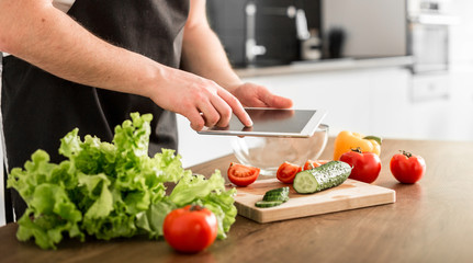 Young trendy man cooking healthy food in the morning