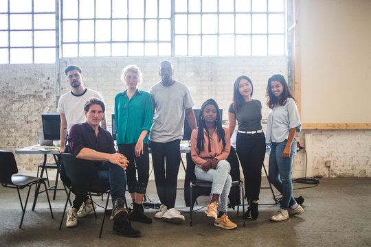 Portrait of confident young programmer's team at creative office