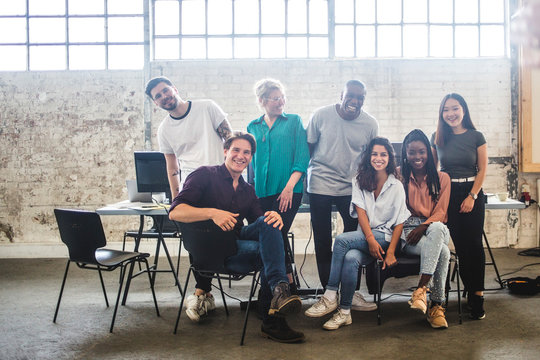 Portrait of cheerful young hacker's team at creative office
