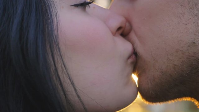 Close-Up on young romantic  lovers Kiss On A Sunset Background