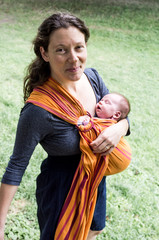 Mère portant son bébé en écharpe