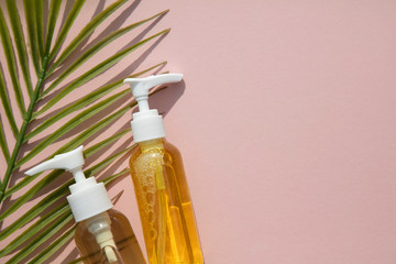 Fototapeta na wymiar Natural cosmetic beauty products in bottles with a green palm leaf