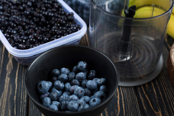 Cooking smoothie blender of wild purple blueberries, bananas. Raw vegan dessert in coconut eco bowl. Idea recipe healthy diet breakfast. Concept losing weight, healthy lifestyle.