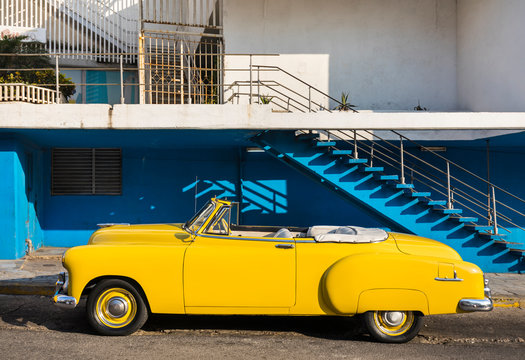 Fototapeta Yellow vintage car parked on road