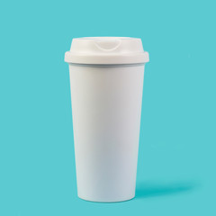 White coffee cup with a lid isolated against blue background