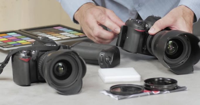 Un photographe ins&eacute;re une carte m&eacute;moire dans son appareil photo