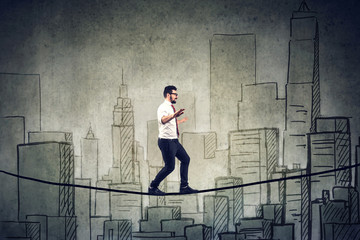 Businessman walking balancing on a rope above a city