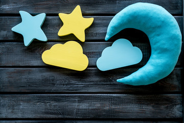 Night sleep concept with moon, clouds, stars toys on wooden background top view