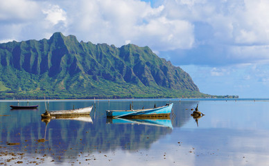 A Perfectly Still Kaneohe Bay Creates a Perfect Reflection on the Mountains and Old Boats
