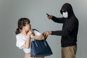 女性を脅して財布を盗む男性