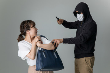 女性を脅して財布を盗む男性