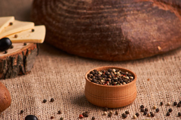 Peppercorns in a wooden bowl on table with food rustic style. Homemade food