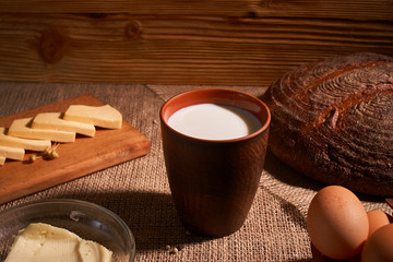 Assorted dairy products milk, cheese, butter rustic still life on table