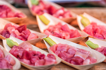 Tokyo, Japan outer market street in Tsukiji with retail display of cubes slices of tuna sashimi...