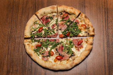 top view of one half and four pieces of pizza with arugula