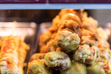 Retail store display of fried battered fish meat, crab balls and fishcake behind window in Tsukiji outer outdoor street market in Ginza, Tokyo Japan