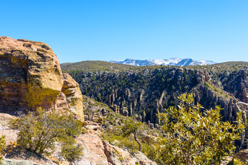 Rock pinnacles afford grand views of snow covered peaks and the valley below in Chiricahua National Monument in Southeastern Arizona.