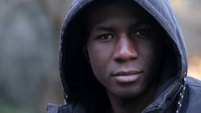 Confident serious attractive african american man with hood staring at camera