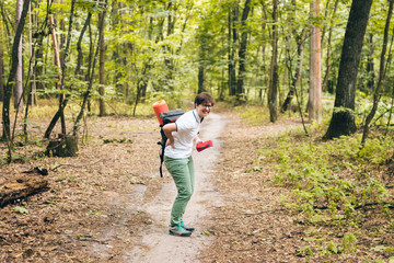 Woman tourist got back injury in forest and gets hurt. Health problem in the journey. Theme Insurance company. Pain in the spine with an active lifestyle. Traveling with backpacks with a sore back