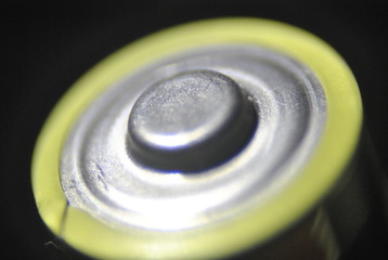 close-up the positive side on the alkaline battery, on the black background
