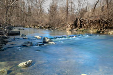 Long exposure of cool clear water running down a small river in Upstate New York