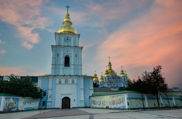 St. Michael's Golden-Domed Monastery with religious paintings on the outer walls just after sunset,...