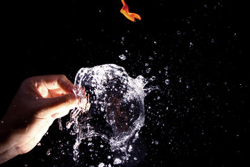 Popping the water balloon on black background
