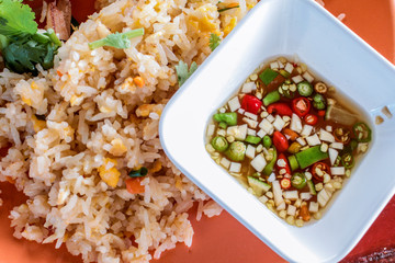 Close up homemade spicy fried rice with vegetables, chili and tuna meat served with lime and chili in fish source Thai food style