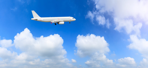 Naklejka na ściany i meble Commercial airplane flying in the blue sky