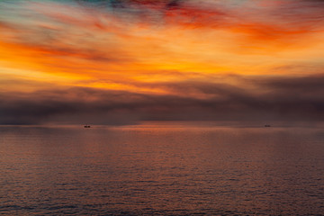 amanecer cálido sobre el mar con grandes nubes coloridas