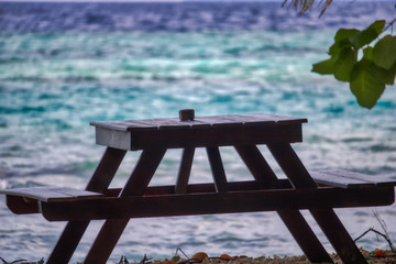 Dieses einzigartige Foto zeigt einen Holztisch, der ein romantischer Ort am Strand der Malediven ist