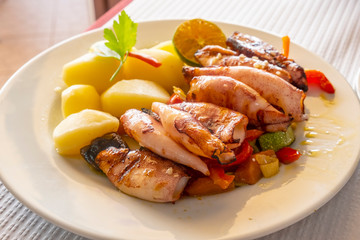 Grilled Baby Squids on a Bed of Roasted Vegetables Served with a Side of Boiled and Pilled Baby Potatoes