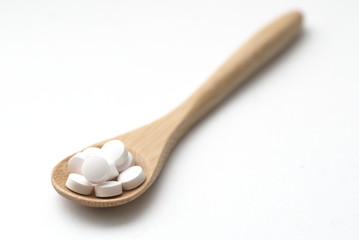 pills on wooden spoon 