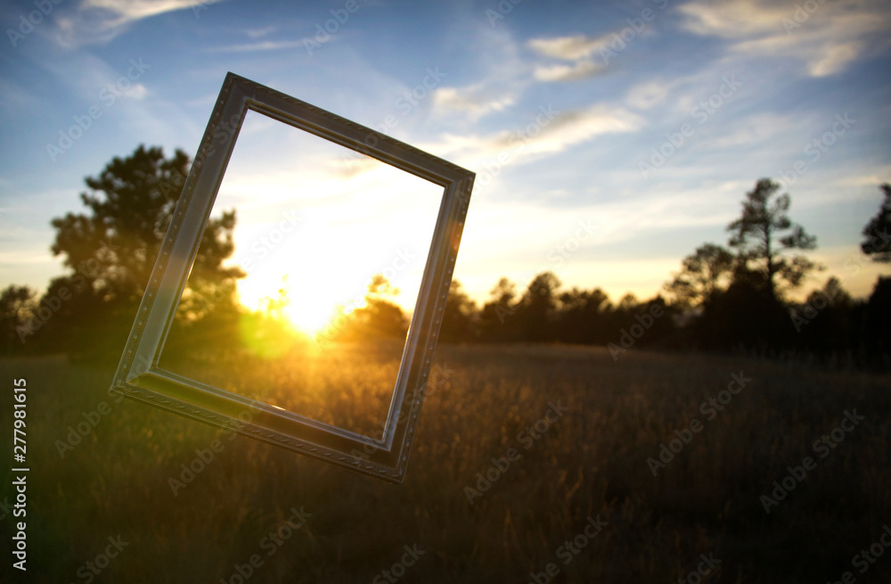 Wall mural picture frame at sunset in field