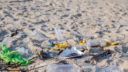 Rubbish and used plastic bottles on the beach. Environmental pollution. Ecological problem