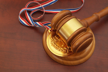 Fototapeta na wymiar Medal and wooden judge's gavel, arbitration court concept.