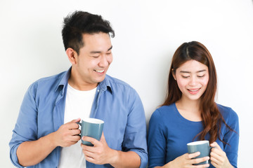 Asian couple in blue shirt on white background with cup of coffee happy and smile mood
