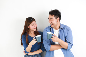 Asian couple in blue shirt on white background with cup of coffee happy and smile mood