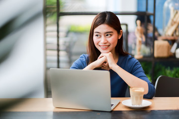 Fototapeta na wymiar Asian business girl working and drinking coffee in cafe