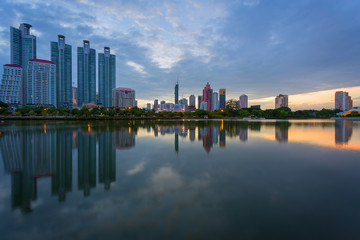 Fototapeta premium Budynek miasta z odbiciem wody przed zachodem słońca