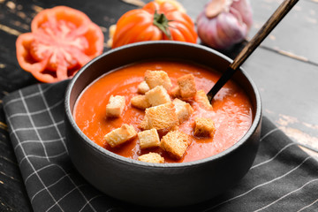 Bowl of tasty tomato cream soup on table