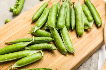 Tasty fresh peas on wooden board, closeup