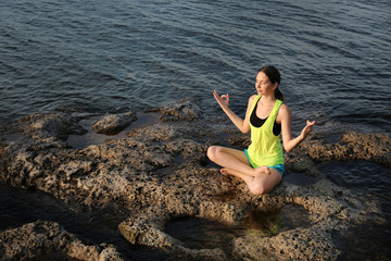 Young woman meditating near river