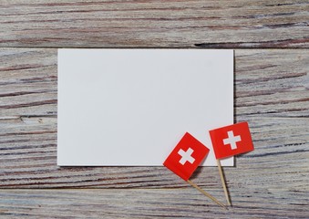  Switzerland, August 1. Federal holiday in honor of the Swiss Confederation. the concept of freedom, Alliance and Union. mini flags with sheets of white paper on wooden background. horizontal