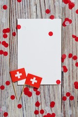 Swiss independence day, August 1. Federal holiday in honor of the founding  Swiss Confederation. day of the Confederacy. flags and confetti with sheets of white paper on a wooden background. vertical