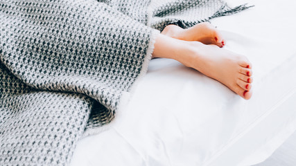 Home textile products. Natural bed linen collection. Interior design. Style and comfort. Woman feet...
