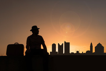 Traveler with suitcase and hat in front of Columbus city skyline in USA